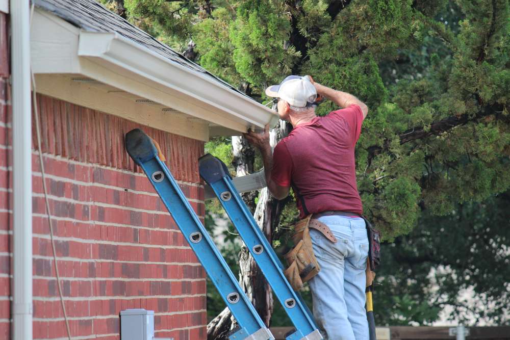 male-contractor-installing-gutter-system-on