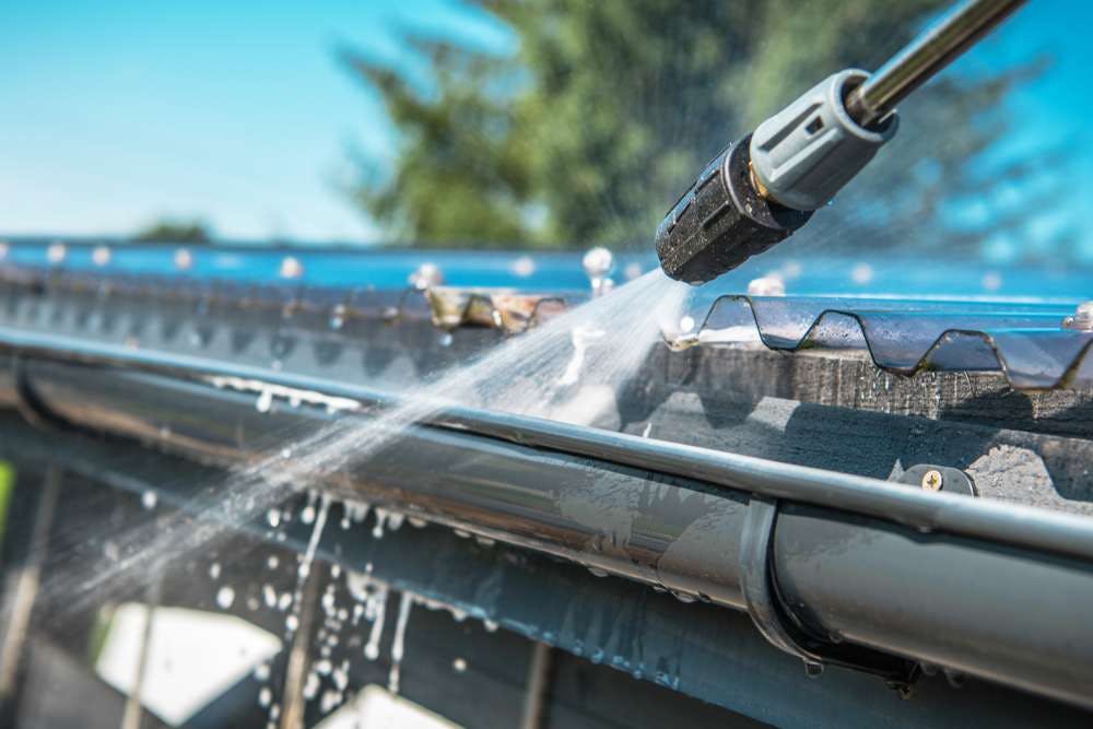 spring-rain-gutters-cleaning-using-pressure