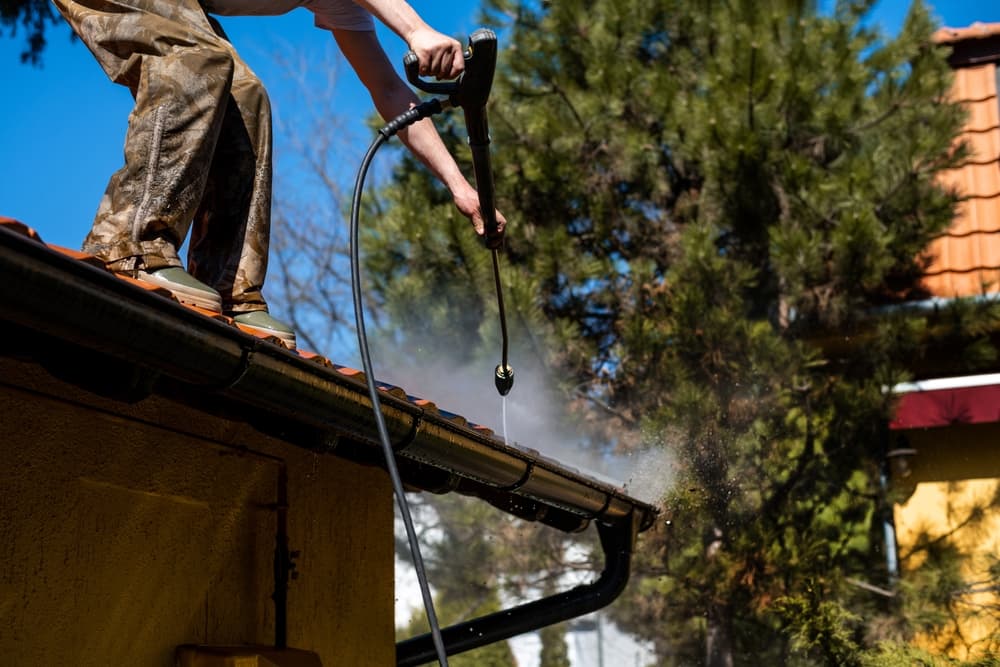 worker-standing-on-roof-cleaning-rain