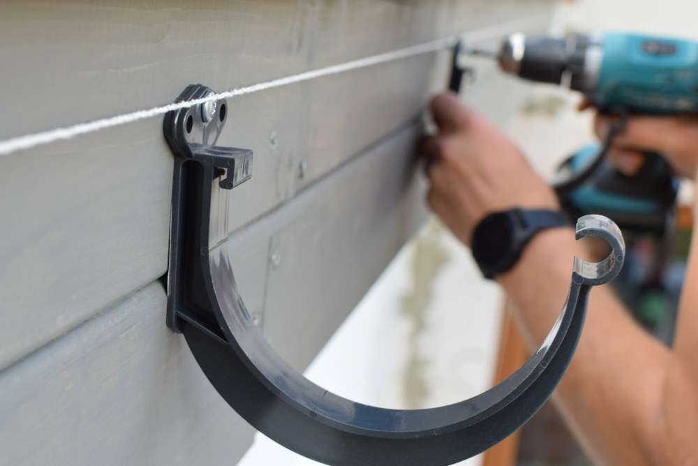 man-hands-installing-dark-grey-plastic